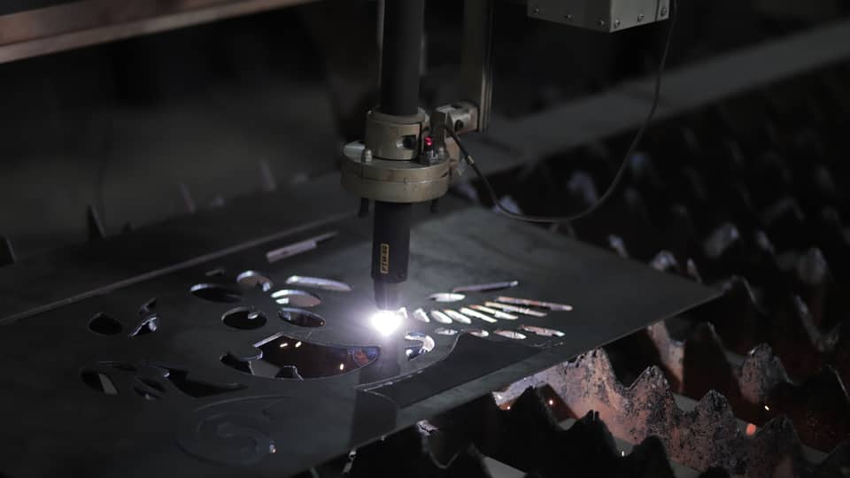 Máquina de corte cortando uma chapa metálica com furos
