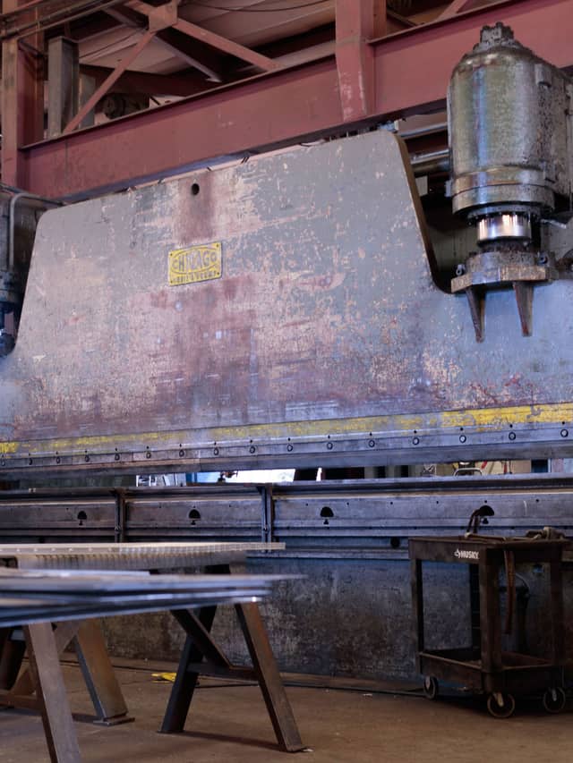 Prensa dobradeira de grande porte em um galpão industrial